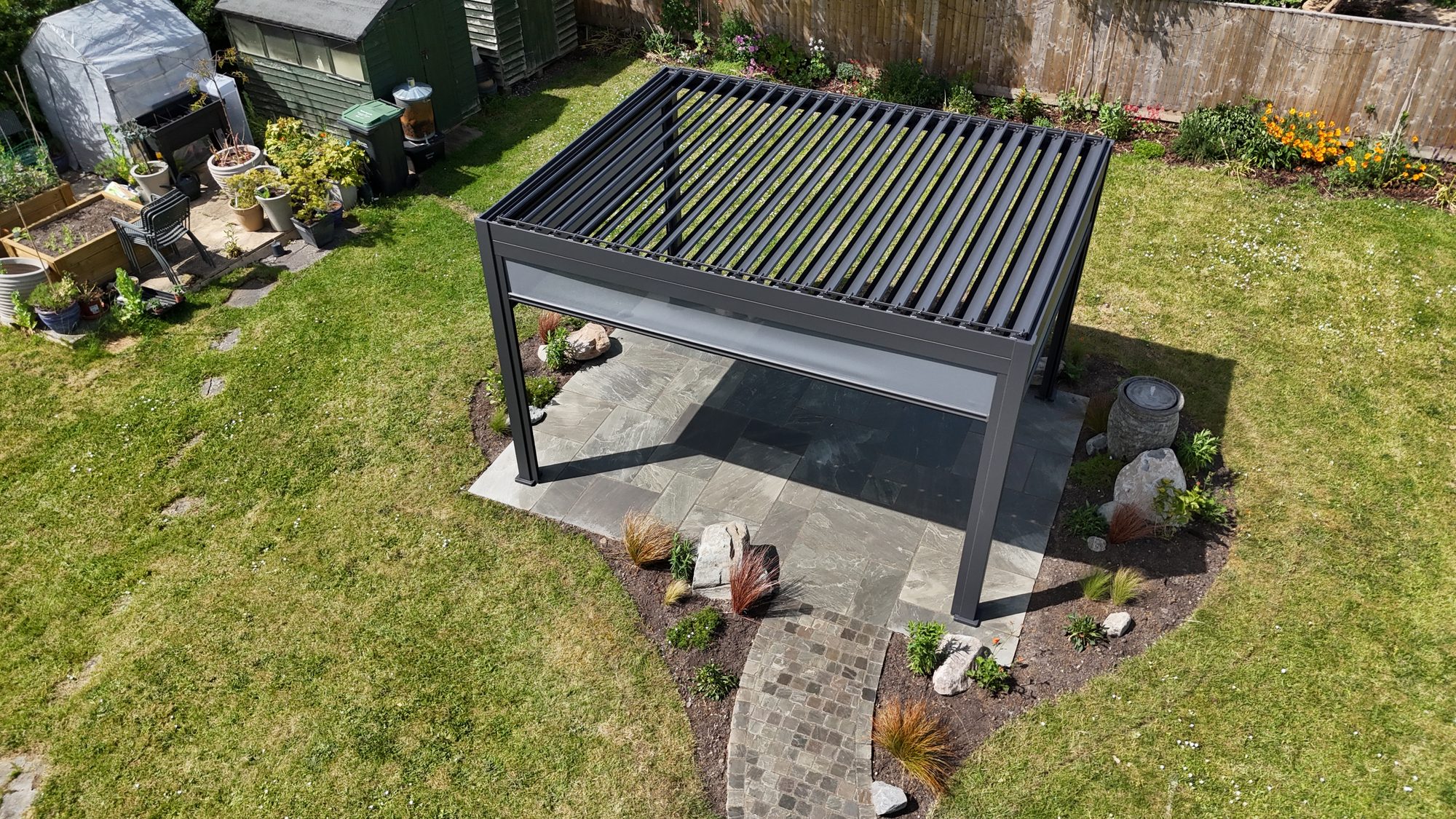 Aerial of an aluminium louvred pergola on a porcelain patio