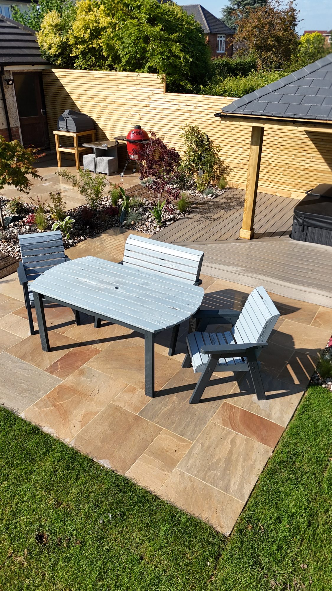 Aerial of a sandstone patio dining area framed by planting