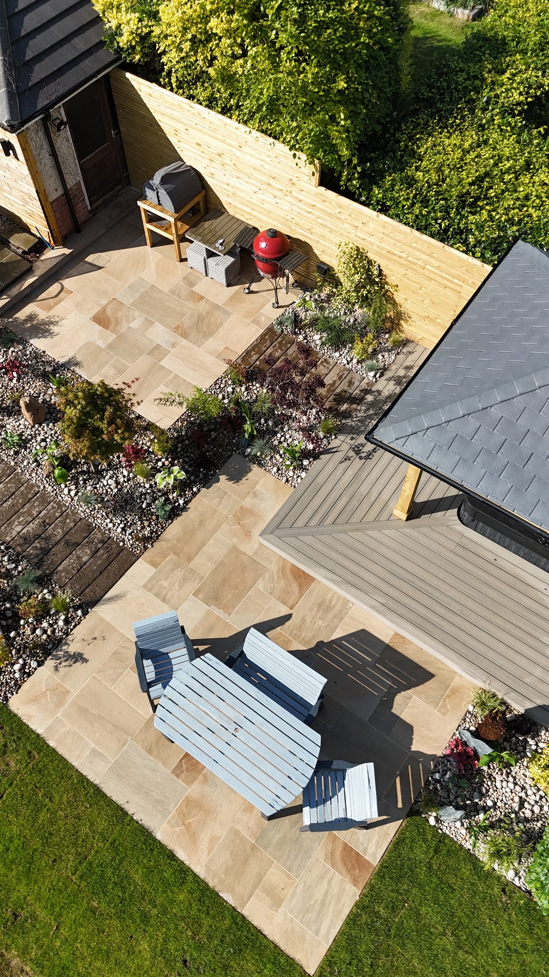 Top-down view of a riven sandstone patio with planted borders